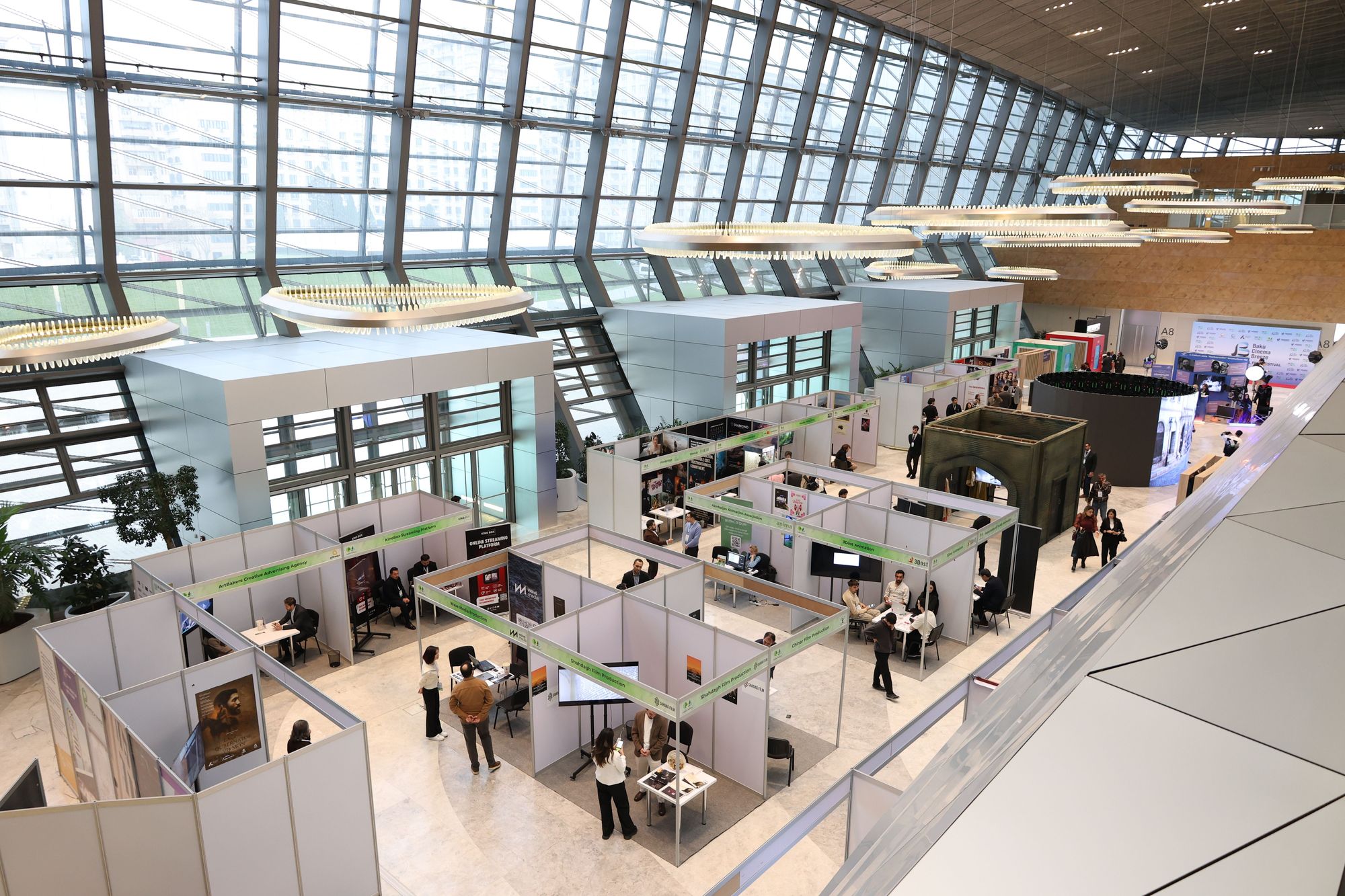 Blick von oben auf eine Halle mit aufgebauten Messeständen